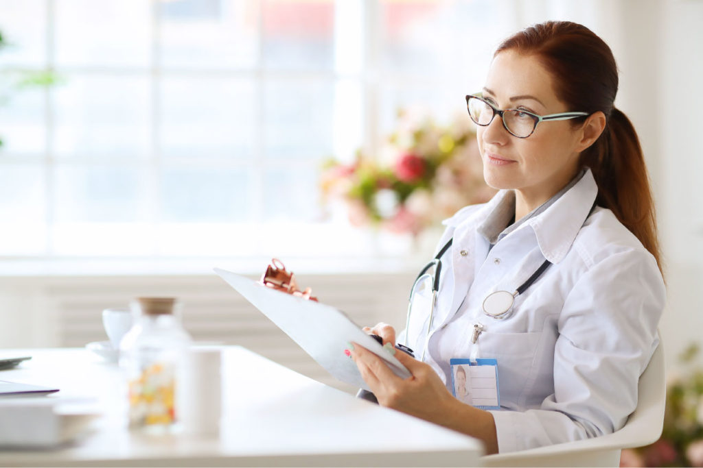 Female doctor with clipboard in bright office